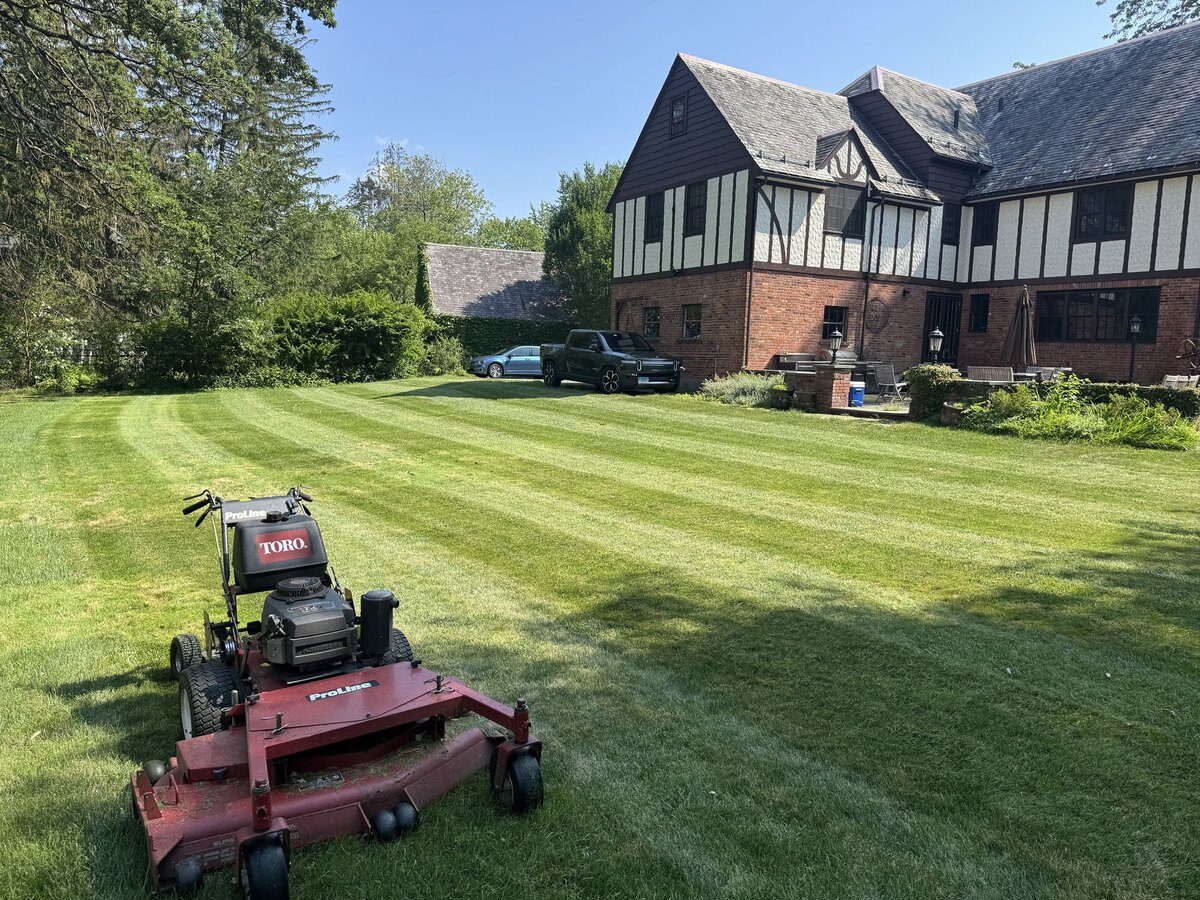 Freshly mowed, evenly graded lawn behind a large home