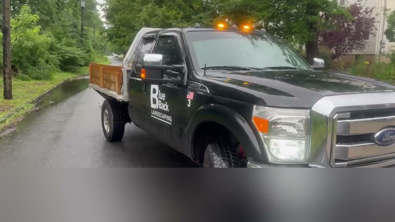 Branded Blue Back Landscaping service truck on a property route